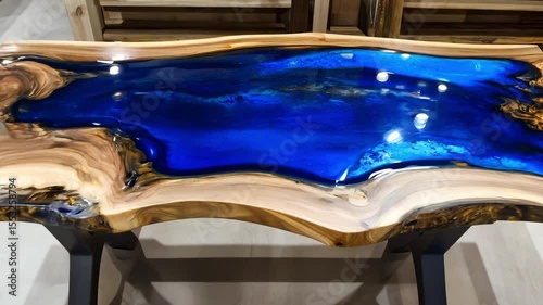 A beautifully crafted river table showcasing vibrant blue resin flowing through natural wood in a contemporary decor environment