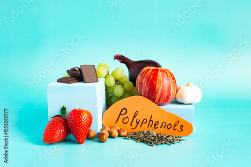 Products containing useful substances and polyphenols in their composition. Grapes, onions, garlic, chocolate and other products in close-up on a light background and the inscription on colored paper 