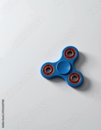 Spinning fun with a blue fidget spinner indoor play area still life photography minimalist design close-up perspective