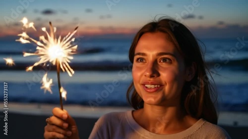 Young woman celebrating with sparkler at beach during sunset  