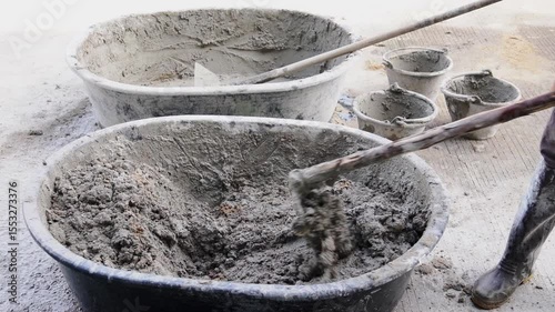 A hoe is used by the worker to mix the cement manually.