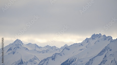 Overcast sky above jagged snowy mountain peaks