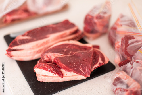 steaks on a chopping board getting packaged for the freezer