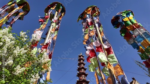 Xining, China: Panoramic footage of tall tibetan buddhist prayer flags on a windy day in the Nanchan Buddhist temple in Xining, Qinghai largest city in China.