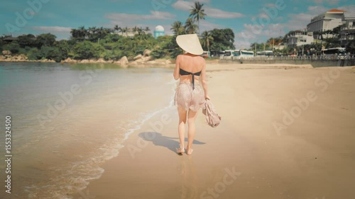 Female traveler walking alone on sea shore and relaxing, lady resting on beach. Summer vacation in central Asia, popular tourist destination, recovery energy and be happy, tanning on sandy shoreline