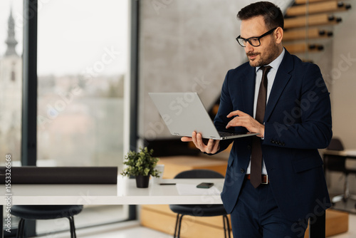 Handsome businessman with laptop at his office