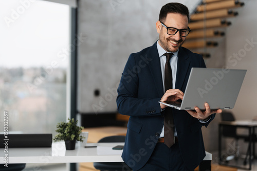 Handsome businessman with laptop at his office