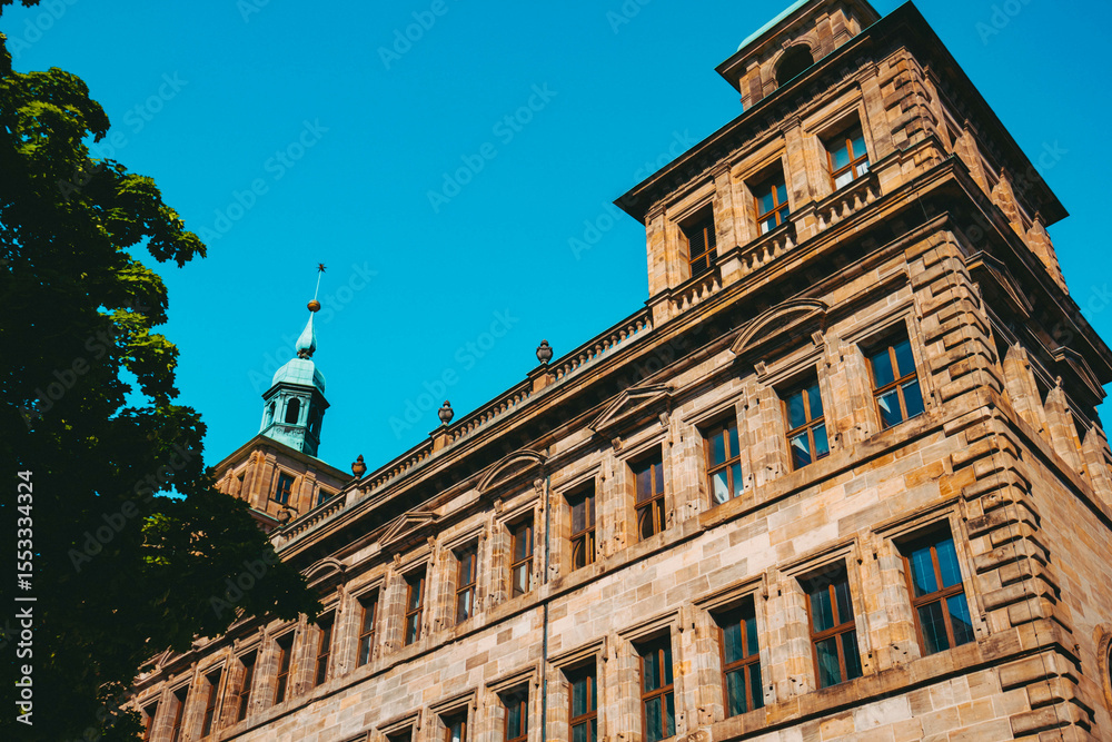 Fototapeta premium Old architectural building in Nuremberg city against blue bright sky. Cityscape