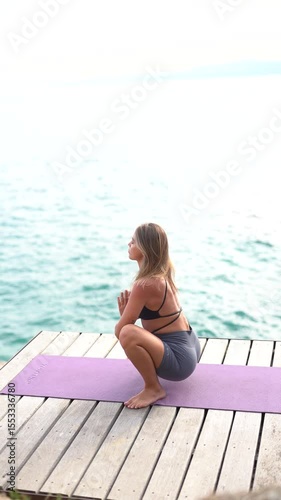 Beautiful girl practicing yoga against the backdrop of the sea.