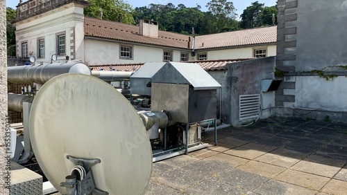Rooftop satellite dish hums quietly, evoking tech nostalgia and digital renaissance, fitting for World Communications Day or International Day of Light
