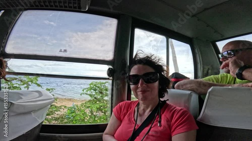 Woman riding on a local bus and enjoying views in Siquijor island, Philippines Woman enjoying scenic ride on a local bus in Siquijor island, Philippines