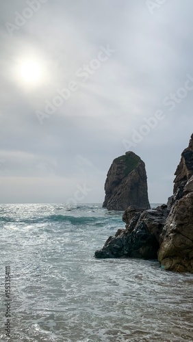 Misty sea-brushed monolith whispers ancient tales, solitude rituals, Midsummer Eve's embrace, oceanic zenith, mythical maritime meditation