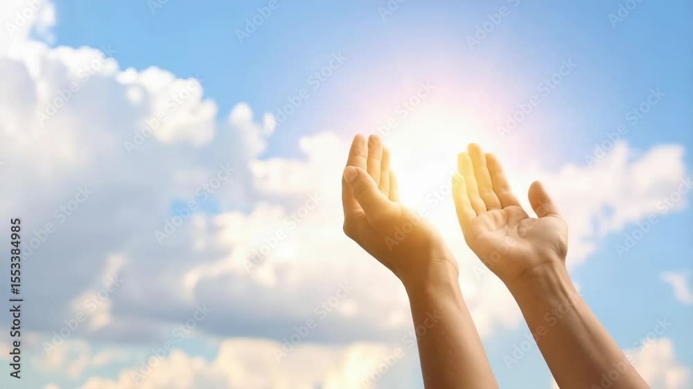 Raised arms toward sunny skies with fluffy clouds, hands reaching for sunlight with bright light in blue sky hope concept