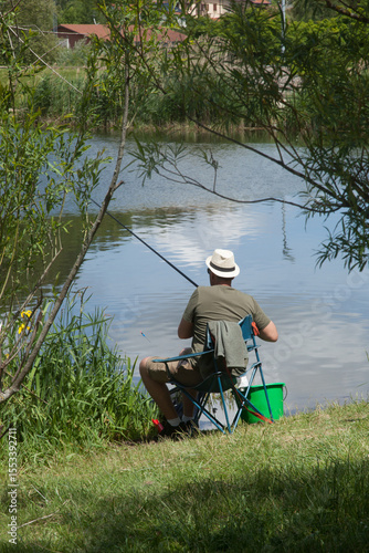 Pêcheur assis sur la rive du lac