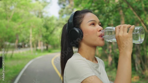 Wallpaper Mural Asian runner woman running to drink water for outdoor exercise, training or recovery after marathon. Healthy fitness exercise concept, healthy athlete and cardio running. Torontodigital.ca