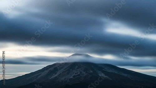 Volcano peak with horizontal cloud layer during twilight sky scenery, seamless looping 4k time-lapse animation video background. Nature concept