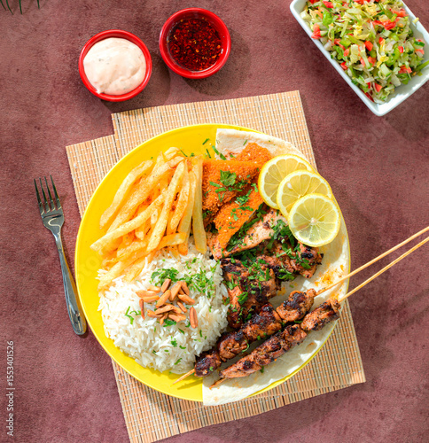 Luxury Western mixed grill meal, shish tawook with chicken, rice, and French fries.