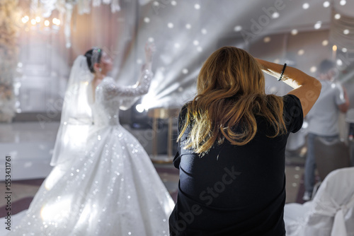 Wedding photographer takes pictures of the beautiful bride and groom in the restaurant hall.