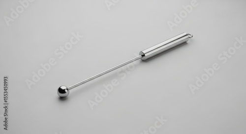 A Sleek, Polished Metal Tool with a Ball and Cylinder Shape on a Light Surface