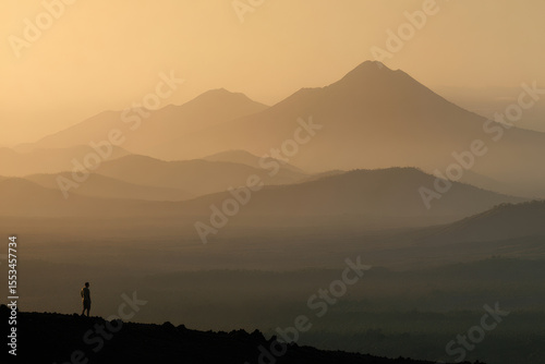minimalist photograph of solitary human figure in volcanic caldera in nicaragua during golden hour