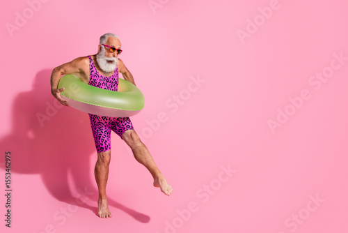 Photography Photo of bearded pensioner man wear swimwear hold lifebuoy foot touch water empt