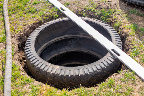 A pit for an outdoor village toilet with walls made of rubber tires. Making a toilet on a personal plot
