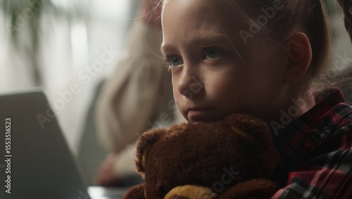 Caucasian family at home father working online with laptop ignoring sad frustrated offended upset lonely daughter hugging Teddy Bear toy child kid girl suffering dad ignorance attention deficit bored