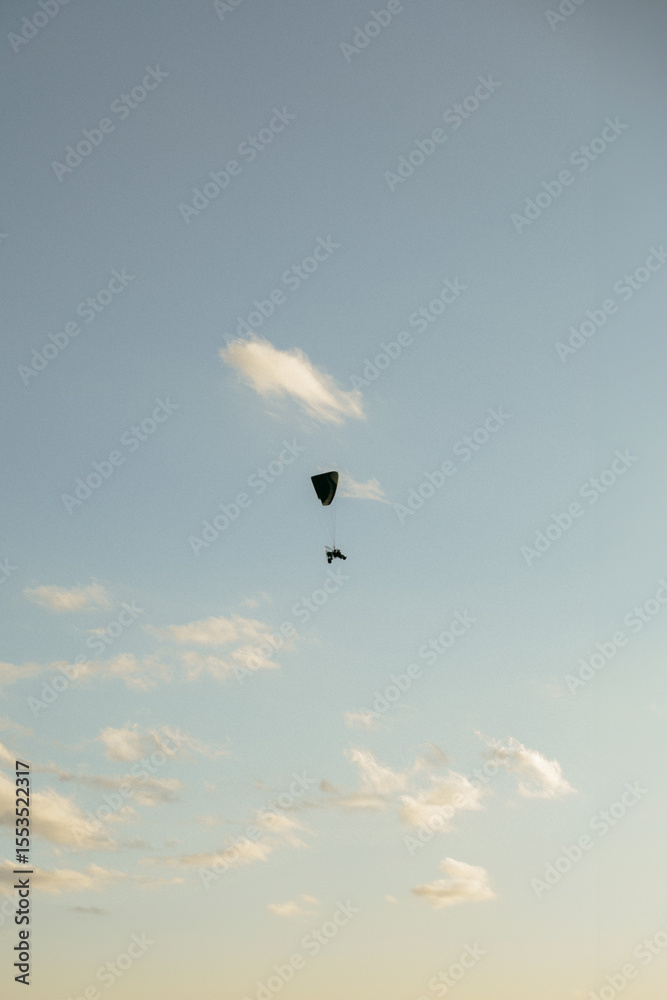 Fototapeta premium Paramotor, motorized parachute flying in the blue skies of a sunny day