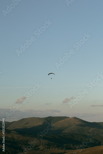 Paramotor, motorized parachute flying in the blue skies of a sunny day