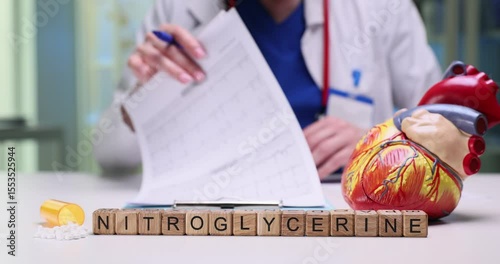 A healthcare professional reviews paperwork for nitroglycerin with a detailed heart model on the table