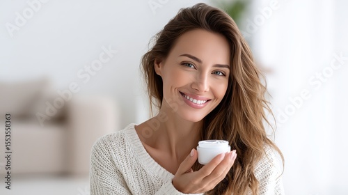 Woman applying skincare cream in bright indoor space during the day