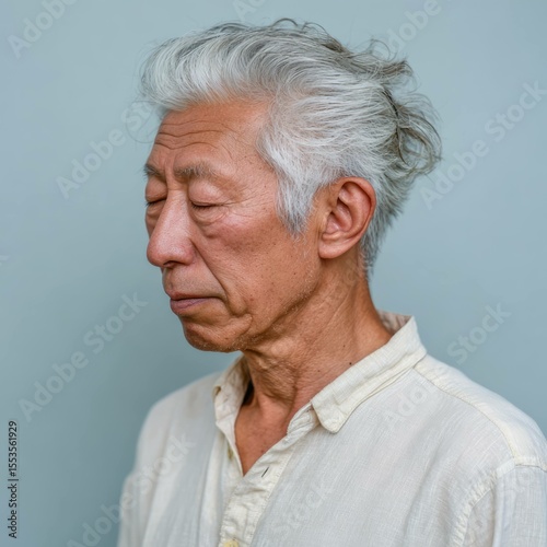 Elegant profile of a senior japanese man with gray hair urban setting portrait photography natural lighting