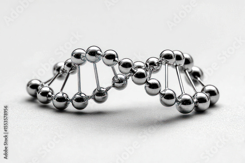 A metallic DNA double helix rests on a smooth surface, showcasing the concept in a striking way