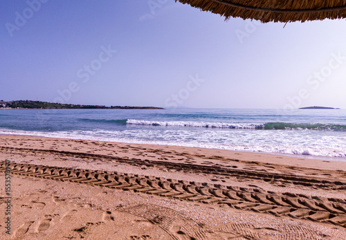 Beach, sea, empty sky and island in the distance