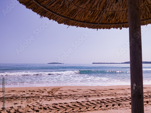 Beach, sea, empty sky and island in the distance