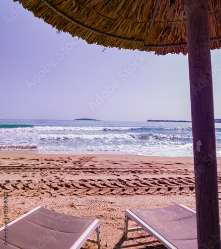 Beach, sea, empty sky and island in the distance