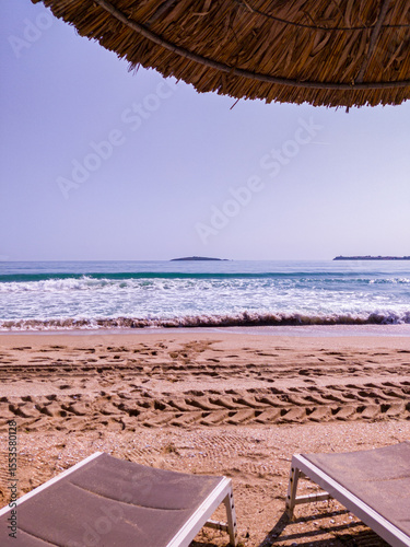 Beach, sea, empty sky and island in the distance