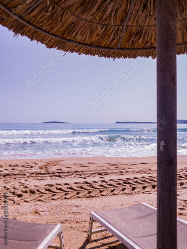Beach, sea, empty sky and island in the distance