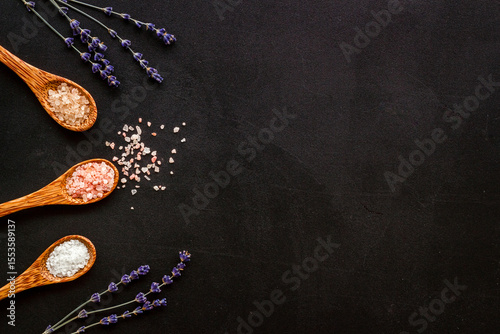 Spa flat lay with many spoons full of sea salt and scrubs, top view. Body care cosmetics