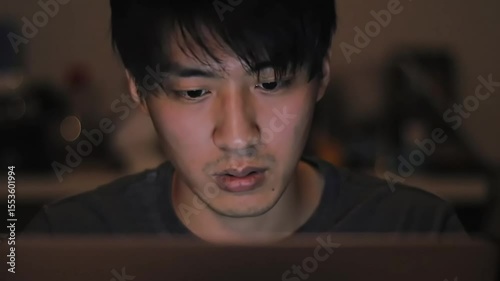 Man using laptop at night, blurred background