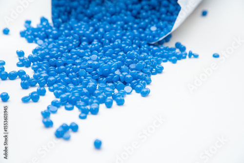 Lots of blue wax granules scattered on white background