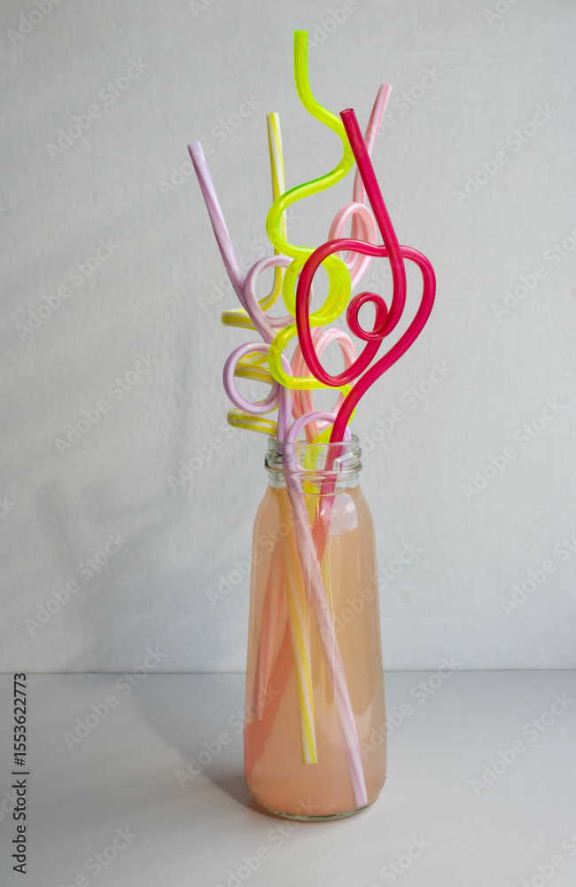 custom made wallpaper toronto digitalA glass bottle of pink drink with colorful straws. Cocktail straw day.