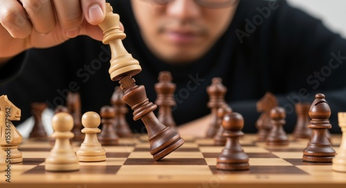 Close-up of a chess game in progress, with a king falling. Represents strategic thinking, competition, and decisive moves.