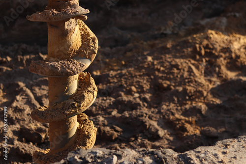Soil drill in the rays of the setting sun, close-up. Special construction equipment. Repair work. Construction activities on a construction site. Close-up of drilling equipment. Geotechnical drilling