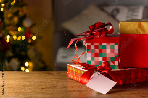 Christmas Gift Boxes with Red Ribbons and Tag on Wooden Table