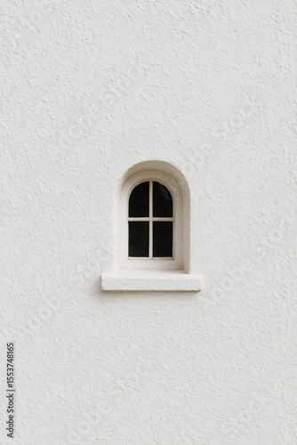 Charming small arched window with bright white panes on a textured wall, minimalist architectural feature and serene design