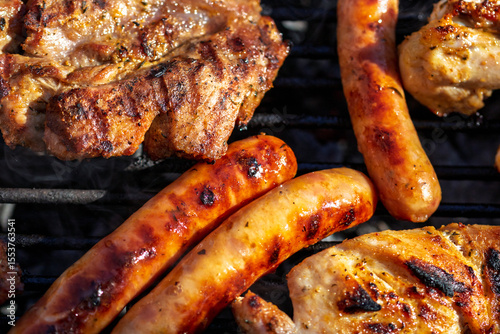 Pork chops, steak, sausages on barbecue grill
