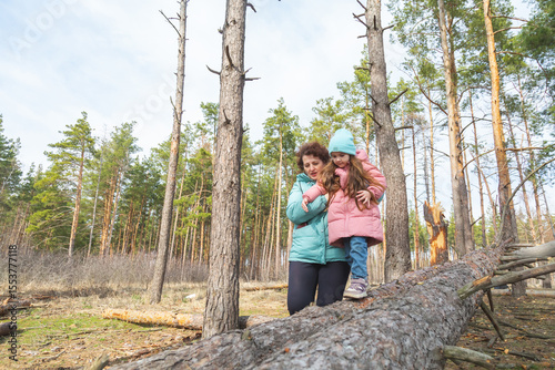 grandmother with granddaughter walking and playing in nature in the forest