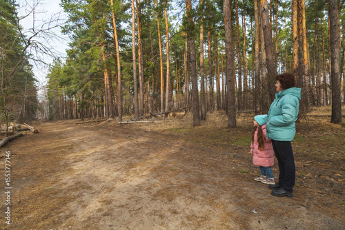 Grandmother and granddaughter walking in the forest