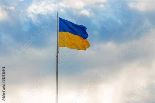 Ukrainian waving flag independence day wallpaper concept poster with light glare empty copy space and blurred sky background